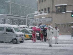 晴れ着姿の新成人と交通整理のおまわりさん